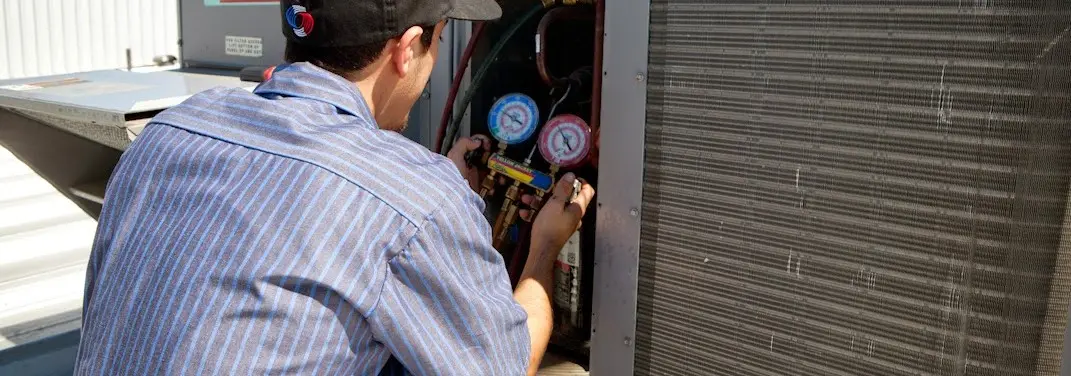 HVAC technician servicing a condenser unit in Union Gap